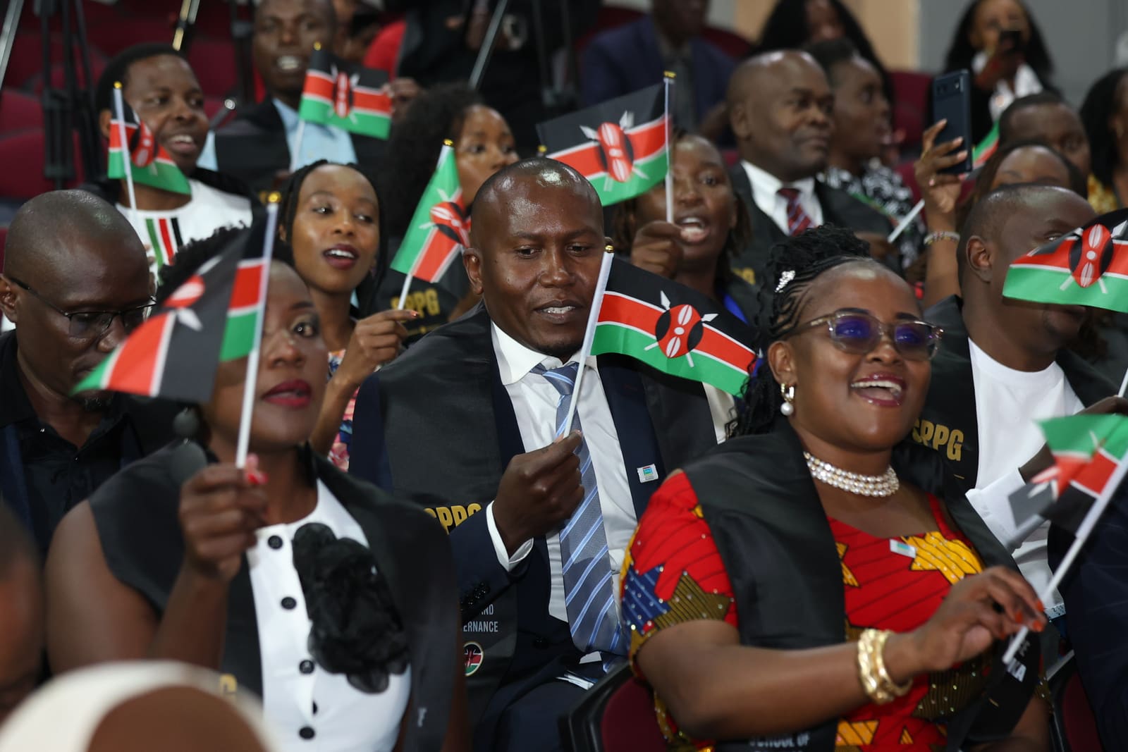 Des étudiants de SPPG Kenya agitant des drapeaux lors de la cérémonie de la Cohorte Pionnière
