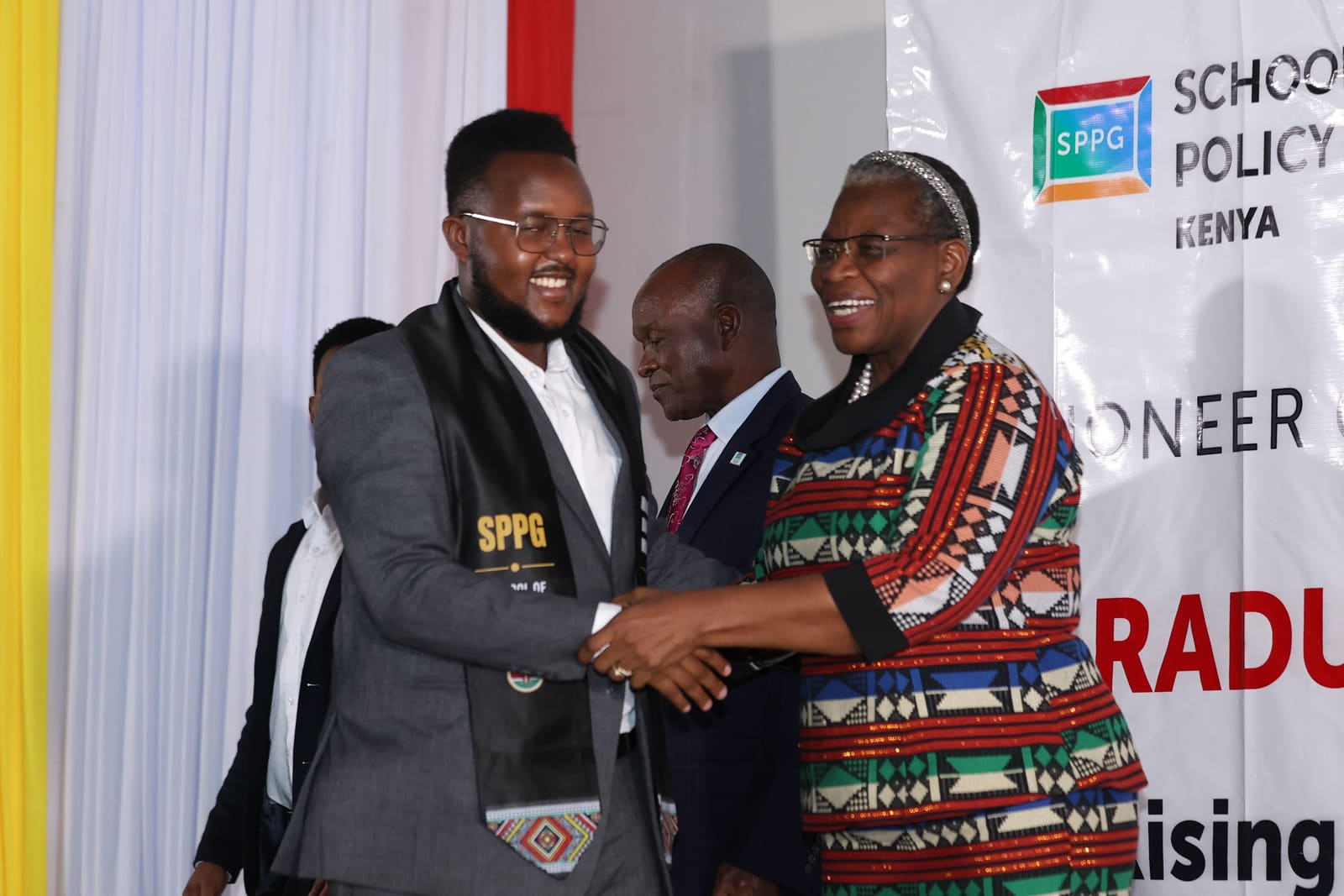 A Kenyan graduate congratulated on stage